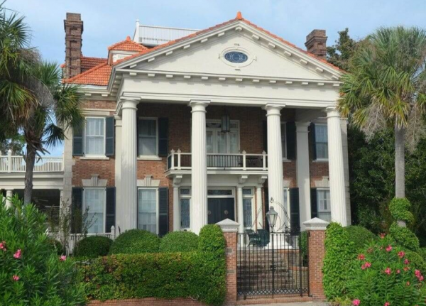 Rumah dengan pilar-pilar megah dan dinding batu alami yang menonjolkan kemegahan arsitektur Eropa klasik